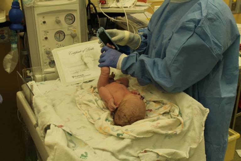 The nurse getting Grayson's footprints.